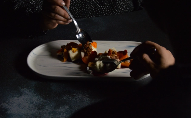 Dîner dans le noir avec un plat gastronomique partagé entre deux convives