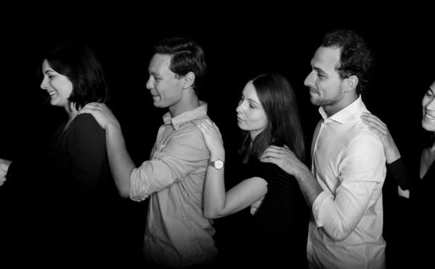 Chaîne de collaborateurs se guidant les yeux fermés dans l’obscurité lors d’un team building immersif